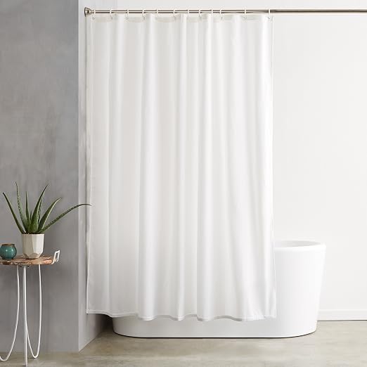 Cortina blanca Amazon Basics colgada sobre una bañera