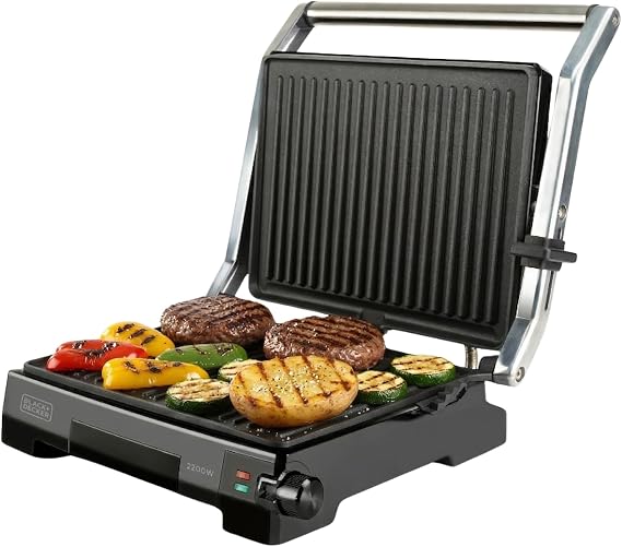 Grill de contacto BLACK+DECKER abierto con verduras y carne, placas estriadas, asa metálica y selector frontal